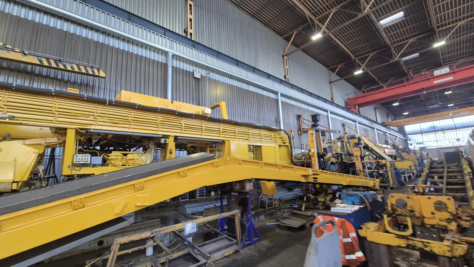 Fertig lackierte Gleisbaumaschine von Plasser & Theurer in voller Länge in der Werkshalle